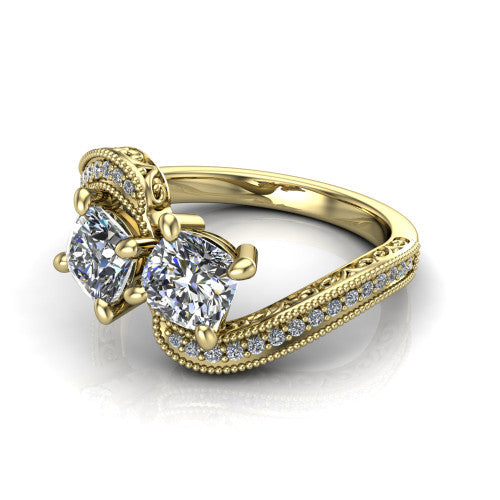 Stevie cushion three stone engagement ring in 14K Yellow Gold, three-quarter perspective showing two brilliant cushion-cut diamonds set diagonally on filigree shoulders with milgrain edges and a pave center band