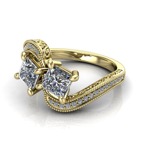 Stevie princess three stone engagement ring in 18K Yellow Gold, three-quarter perspective showing two brilliant princess-cut diamonds set diagonally on filigree shoulders with milgrain edges and a pave center band