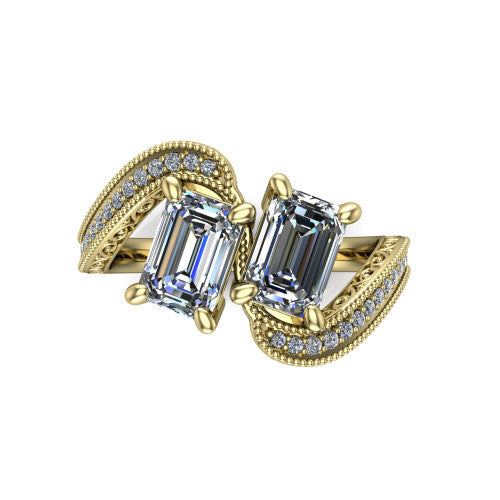 Stevie emerald three stone engagement ring in 18K Yellow Gold, top-down view showing two step-cut emerald diamonds set diagonally in a toi et moi arrangement above filigree scrollwork shoulders and a pave band