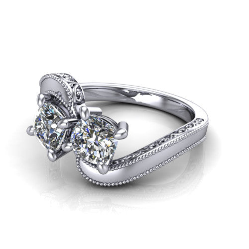 Logan cushion three stone engagement ring in Platinum, three-quarter perspective showing two brilliant cushion-cut diamonds set diagonally on engraved filigree shoulders with milgrain edges