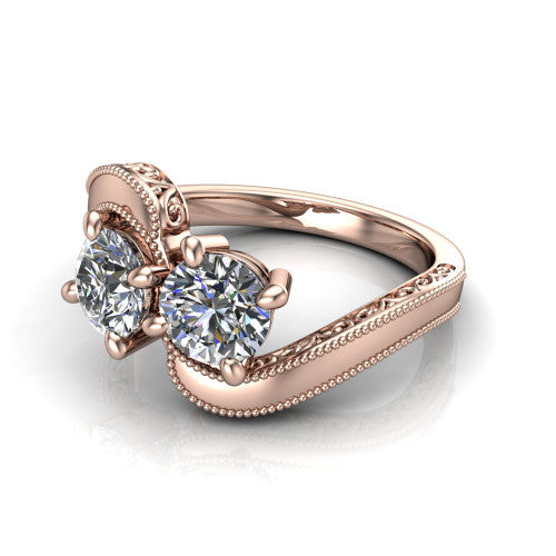 Logan round three stone engagement ring in 18K Rose Gold, three-quarter perspective showing two brilliant round diamonds set diagonally on engraved filigree shoulders with milgrain edges
