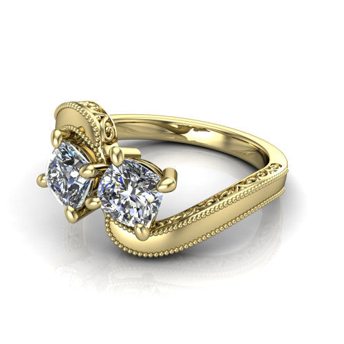 Logan cushion three stone engagement ring in 14K Yellow Gold, three-quarter perspective showing two brilliant cushion-cut diamonds set diagonally on engraved filigree shoulders with milgrain edges