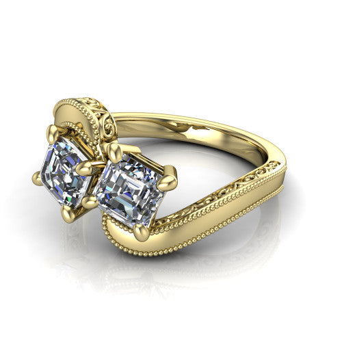 Logan square emerald three stone engagement ring in 14K Yellow Gold, three-quarter perspective showing two step-cut square emerald diamonds set diagonally on engraved filigree shoulders with milgrain edges