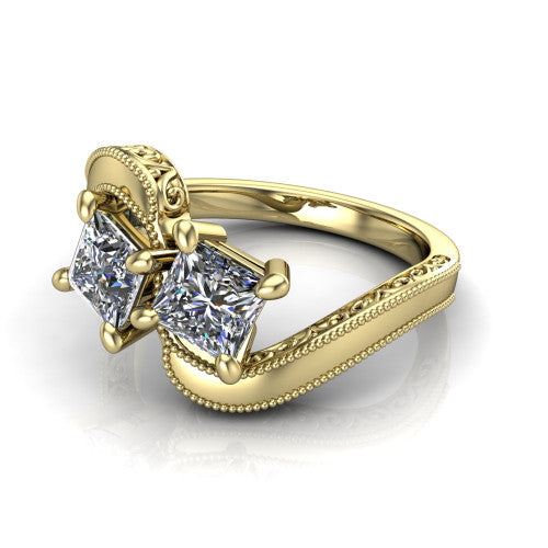 Logan princess three stone engagement ring in 14K Yellow Gold, three-quarter perspective showing two brilliant princess-cut diamonds set diagonally on engraved filigree shoulders with milgrain edges