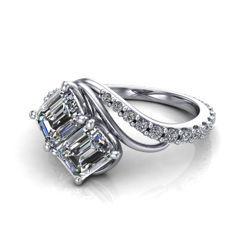 Gwen emerald three stone engagement ring in Platinum, three-quarter perspective showing two step-cut emerald diamonds set diagonally on a pave wraparound shank with bypass curving shoulders