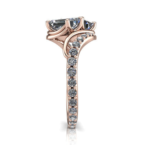 Gwen emerald three stone engagement ring in 18K Rose Gold, side profile showing the bypass curving shoulders and pave diamonds wrapping the top and outer sides of the shank
