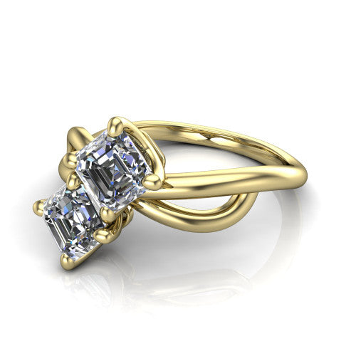 Mya square emerald three stone engagement ring in 14K Yellow Gold, three-quarter perspective showing two step-cut square emerald diamonds set diagonally on a polished infinity-loop shank