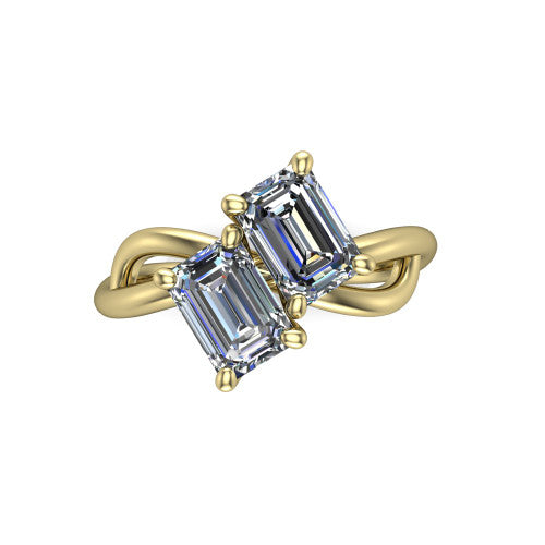 Mya emerald three stone engagement ring in 18K Yellow Gold, top-down view showing two step-cut emerald diamonds set diagonally in a toi et moi arrangement above the infinity-loop shank