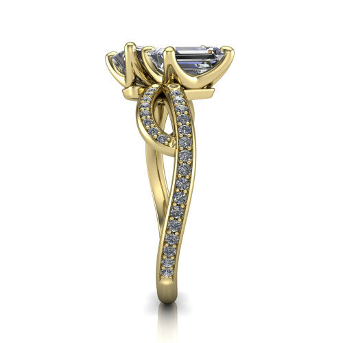 Angelina emerald three stone engagement ring in 18K Yellow Gold, side profile showing the band crossing beneath the head as a pave-covered infinity loop