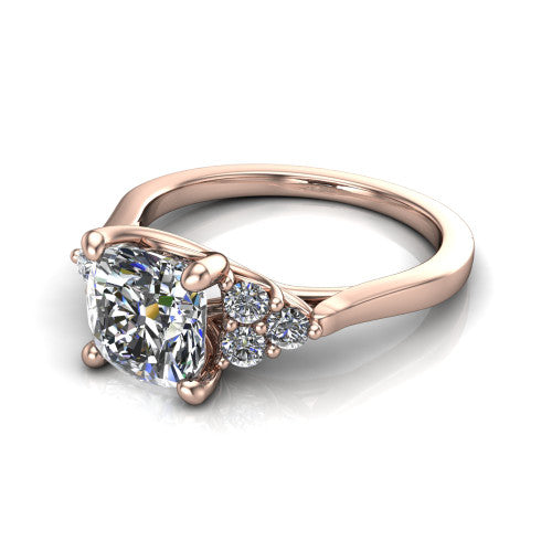 Raegan cushion three stone engagement ring in 14K Rose Gold, three-quarter perspective showing the brilliant cushion-cut center diamond flanked by two triangular clusters of small round accent diamonds