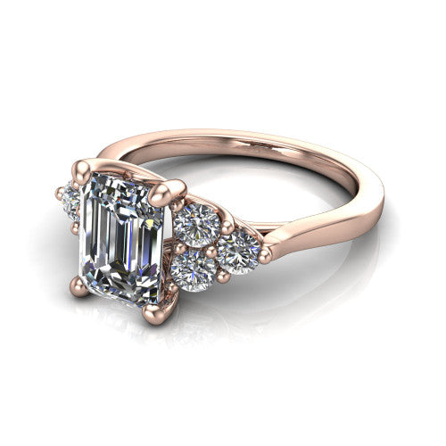 Raegan emerald three stone engagement ring in 14K Rose Gold, three-quarter perspective showing the step-cut emerald center diamond flanked by two triangular clusters of small round accent diamonds