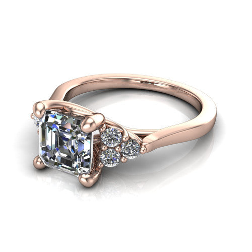 Raegan square emerald three stone engagement ring in 14K Rose Gold, three-quarter perspective showing the step-cut square emerald center diamond flanked by two triangular clusters of small round accent diamonds