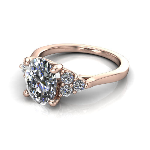 Raegan oval three stone engagement ring in 18K Rose Gold, three-quarter perspective showing the brilliant oval center diamond flanked by two triangular clusters of small round accent diamonds