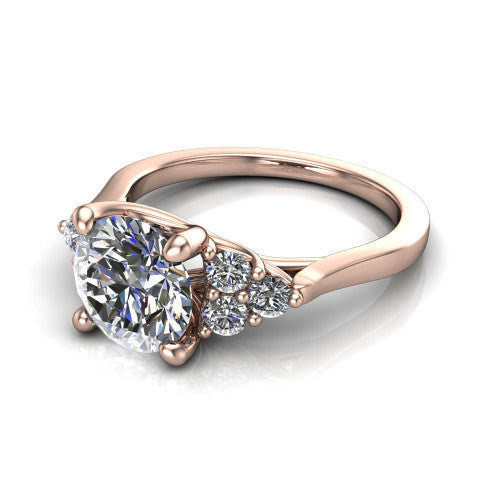 Raegan round three stone engagement ring in 18K Rose Gold, three-quarter perspective showing the brilliant round center diamond flanked by two triangular clusters of small round accent diamonds