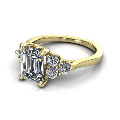 Raegan emerald three stone engagement ring in 18K Yellow Gold, three-quarter perspective showing the step-cut emerald center diamond flanked by two triangular clusters of small round accent diamonds