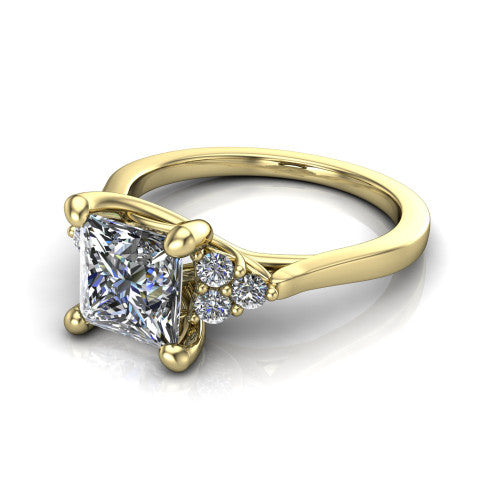 Raegan princess three stone engagement ring in 18K Yellow Gold, three-quarter perspective showing the brilliant princess-cut center diamond flanked by two triangular clusters of small round accent diamonds