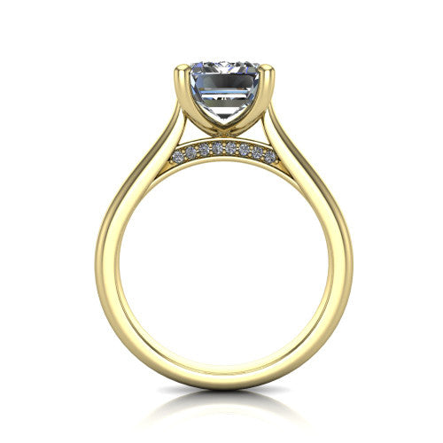 Madilyn emerald solitaire engagement ring in 18K Yellow Gold, through-finger front profile showing the hidden pave accent row beneath the basket and open under-gallery