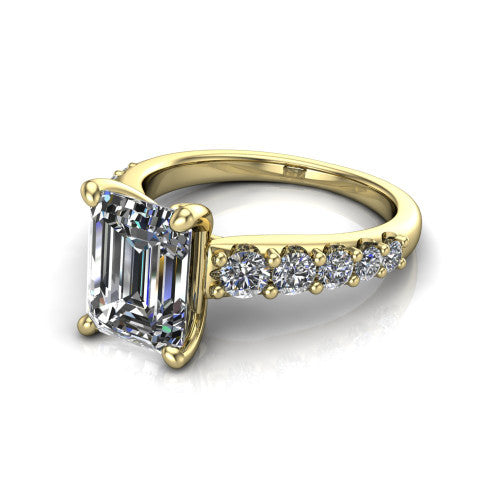 Nina emerald solitaire engagement ring in 18K Yellow Gold, three-quarter perspective showing the step-cut emerald center diamond on a pave-accent shank with a hidden under-halo beneath the center stone