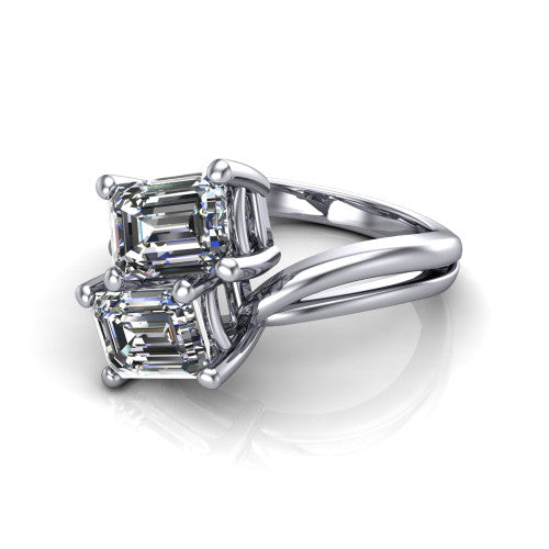 Lexi emerald three stone engagement ring in 18K White Gold, three-quarter perspective showing two step-cut emerald diamonds set diagonally on a bypass split shank with plain bands