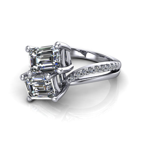 Julieta emerald three stone engagement ring in 18K White Gold, three-quarter perspective showing two step-cut emerald diamonds set diagonally on a bypass split shank with pave diamonds