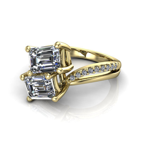 Julieta emerald three stone engagement ring in 14K Yellow Gold, three-quarter perspective showing two step-cut emerald diamonds set diagonally on a bypass split shank with pave diamonds
