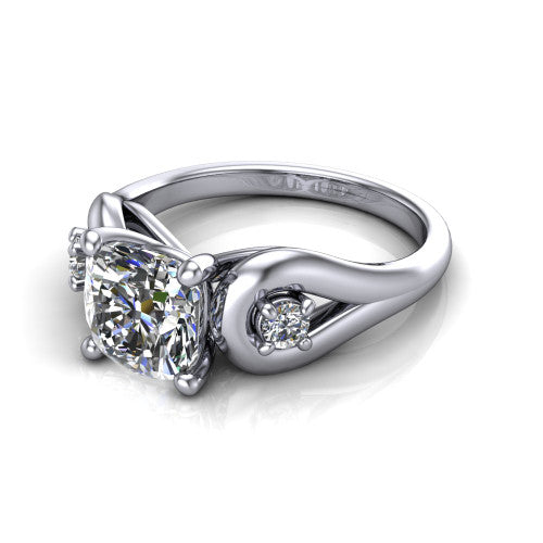 Imani cushion three stone engagement ring in 18K White Gold, three-quarter perspective showing the brilliant cushion-cut center diamond flanked by two round side diamonds in square frames on bypass loop shoulders