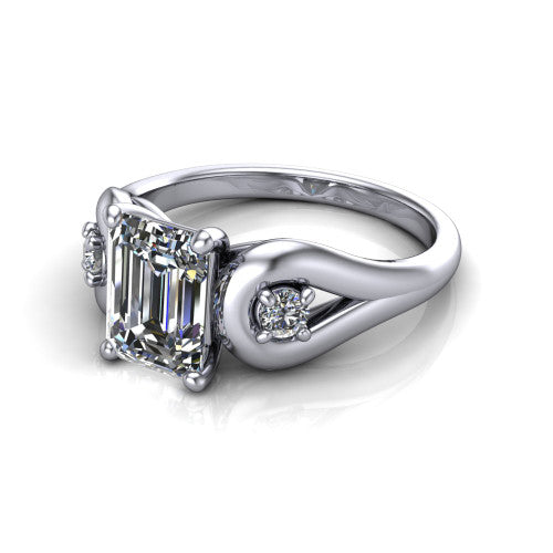 Imani emerald three stone engagement ring in 18K White Gold, three-quarter perspective showing the step-cut emerald center diamond flanked by two round side diamonds in square frames on bypass loop shoulders