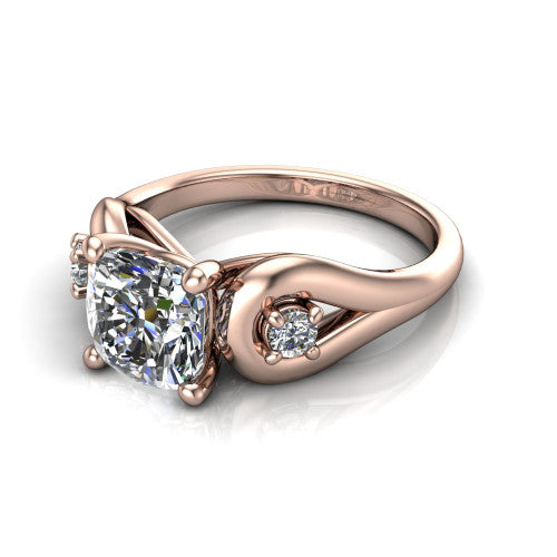 Imani cushion three stone engagement ring in 14K Rose Gold, three-quarter perspective showing the brilliant cushion-cut center diamond flanked by two round side diamonds in square frames on bypass loop shoulders