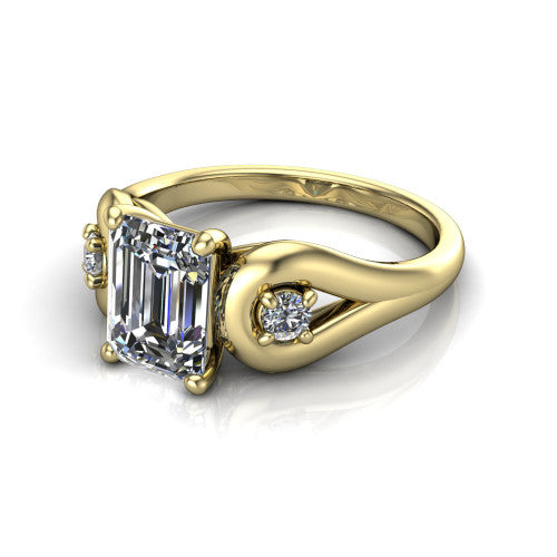 Imani emerald three stone engagement ring in 14K Yellow Gold, three-quarter perspective showing the step-cut emerald center diamond flanked by two round side diamonds in square frames on bypass loop shoulders