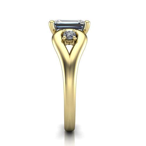 Imani emerald three stone engagement ring in 14K Yellow Gold, side profile showing the bypass loop shoulders curving through the square side frames and slim polished band