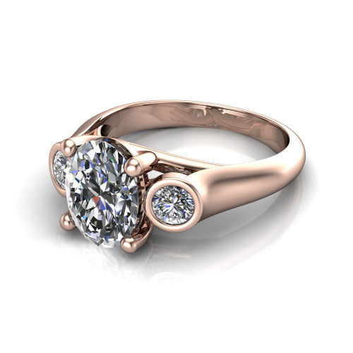 Rory oval three stone engagement ring in 14K Rose Gold, three-quarter perspective showing the oval center diamond between two bezel-set round side stones
