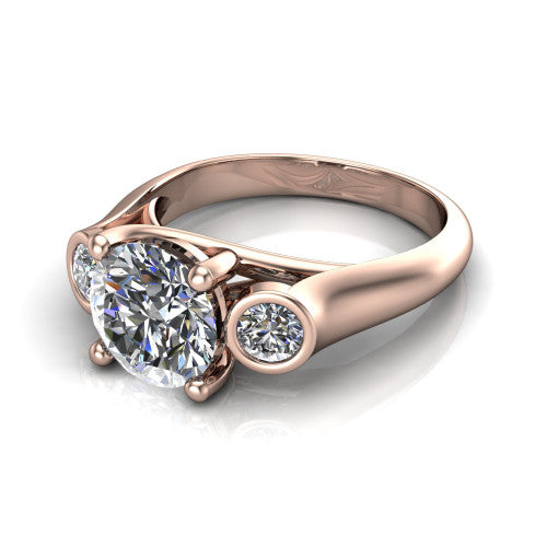 Rory round three stone engagement ring in 18K Rose Gold, three-quarter perspective showing the round center diamond between two bezel-set round side stones