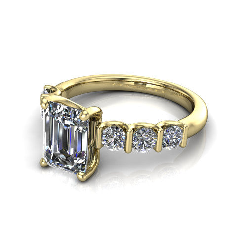 Liora emerald solitaire engagement ring in 18K Yellow Gold, three-quarter perspective showing the emerald center diamond with graduated round side accents on a polished band